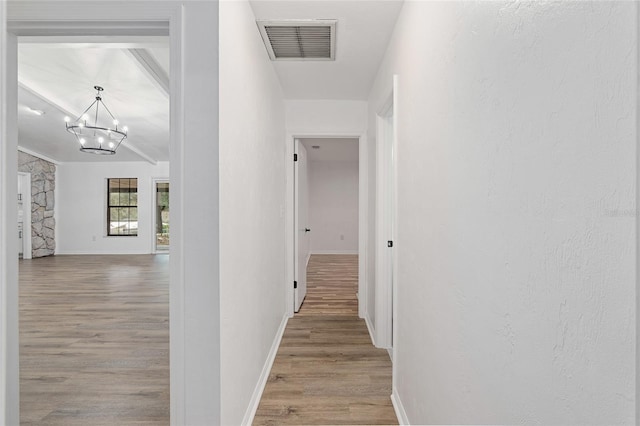 hall featuring light hardwood / wood-style floors and a chandelier