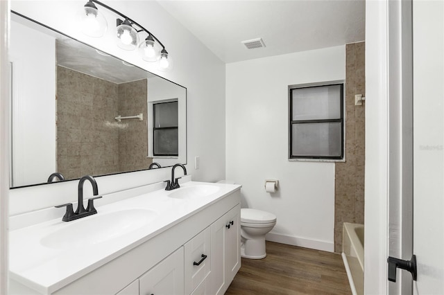 bathroom featuring toilet, vanity, and hardwood / wood-style flooring