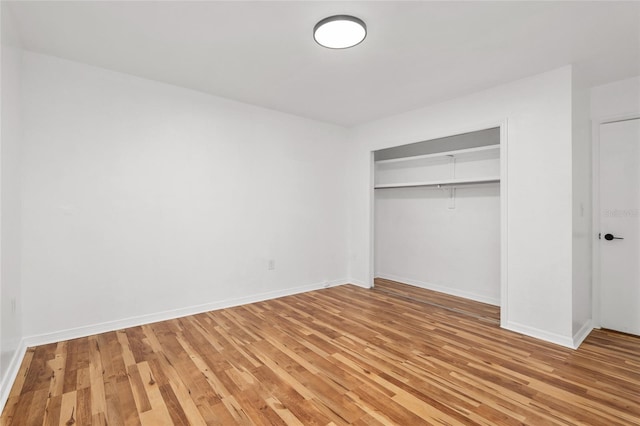 unfurnished bedroom with a closet and light hardwood / wood-style floors