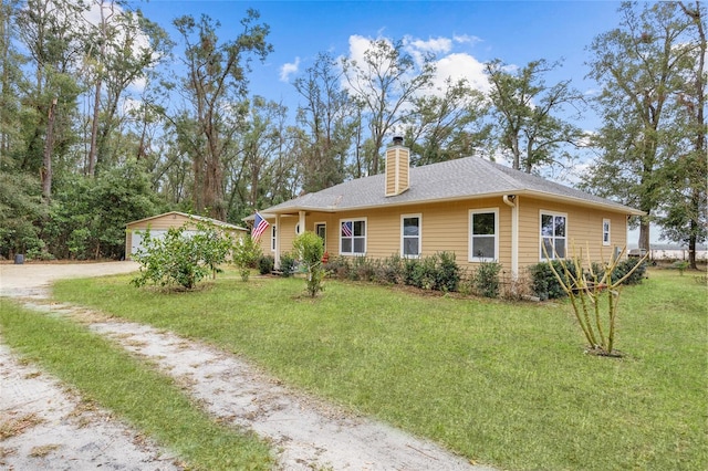 view of side of home featuring an outbuilding, a garage, and a yard