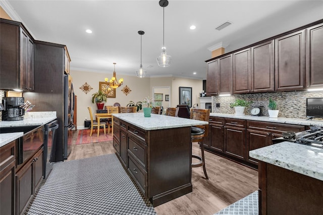 kitchen featuring decorative backsplash, ornamental molding, pendant lighting, and a center island