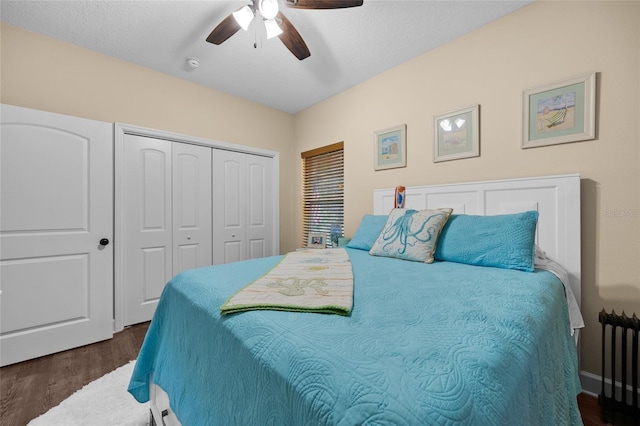 bedroom featuring a closet, radiator, ceiling fan, dark hardwood / wood-style flooring, and a textured ceiling