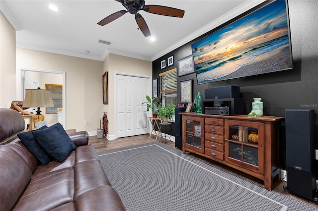 living room featuring ornamental molding, ceiling fan, and dark wood-type flooring