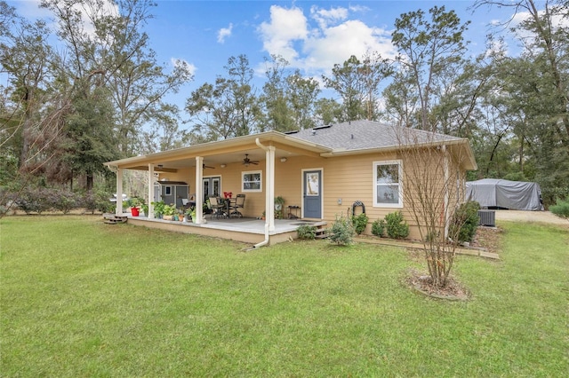 back of property with a lawn, central AC, and ceiling fan