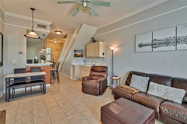 living room with ornamental molding, ceiling fan, and light tile patterned floors