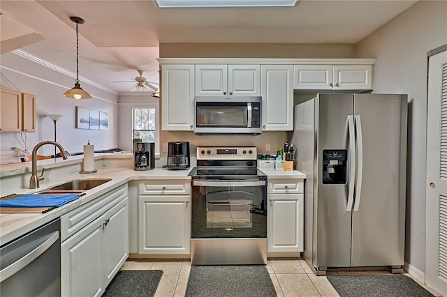 kitchen with stainless steel appliances, white cabinets, sink, and hanging light fixtures