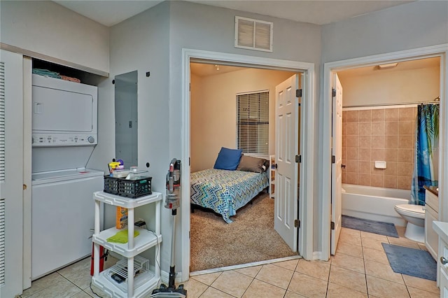 interior space featuring connected bathroom, stacked washer / dryer, and electric panel