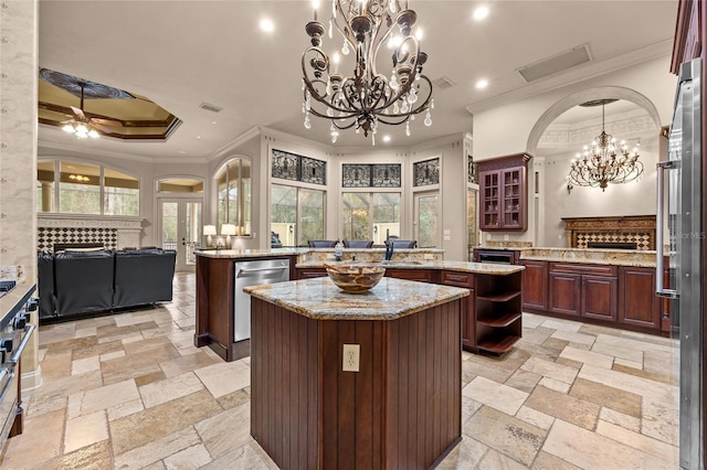 kitchen featuring a tile fireplace, a center island, ornamental molding, ceiling fan, and stainless steel dishwasher