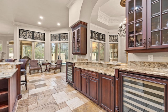 kitchen with dark brown cabinets, wine cooler, and light stone countertops