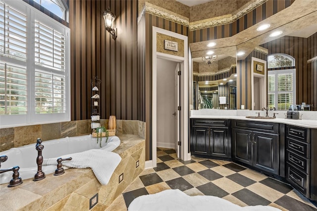 bathroom featuring vanity, plenty of natural light, and tiled tub