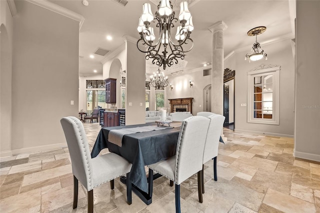 dining space featuring ornamental molding, a notable chandelier, and a fireplace