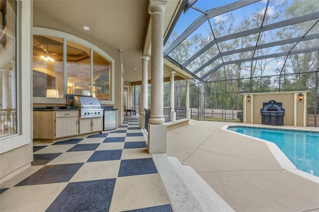 view of swimming pool featuring a patio, a grill, glass enclosure, and exterior kitchen