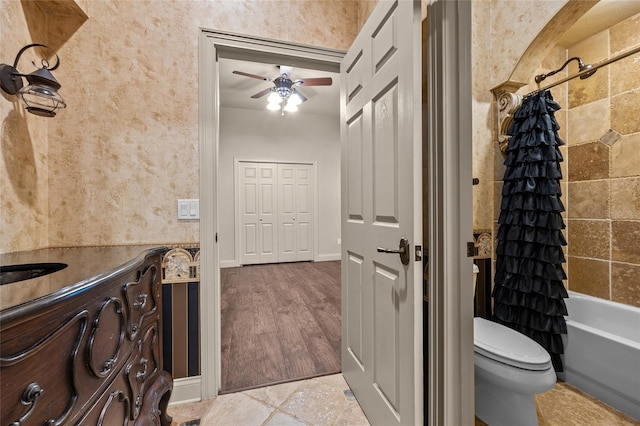 full bathroom with ceiling fan, vanity, shower / bath combo with shower curtain, and toilet