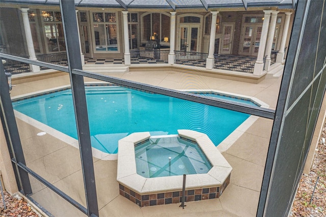 view of pool with a patio area, french doors, and an in ground hot tub