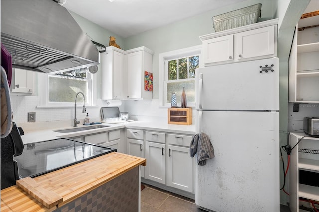 kitchen with white cabinetry, sink, island exhaust hood, and white fridge