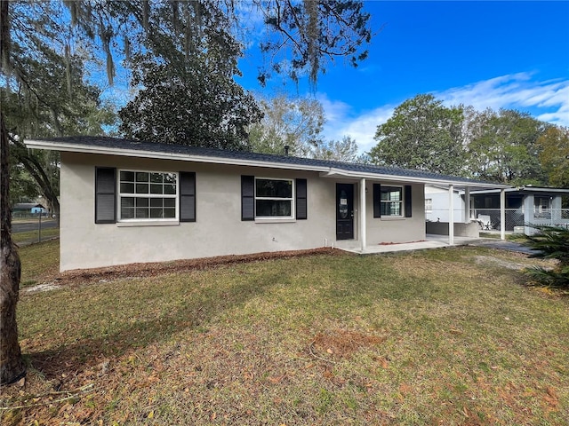 ranch-style home with a front yard and a patio area