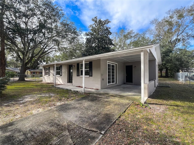 ranch-style house with a carport and a front lawn