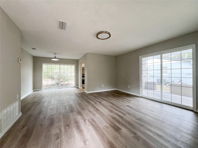 unfurnished living room with a textured ceiling and hardwood / wood-style flooring