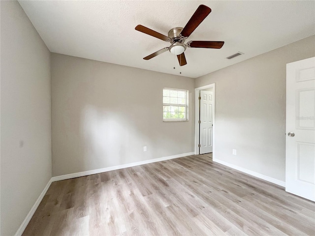 spare room with ceiling fan, light hardwood / wood-style floors, and a textured ceiling