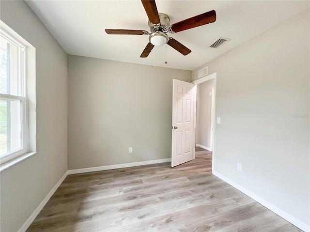 unfurnished room with light wood-type flooring and ceiling fan