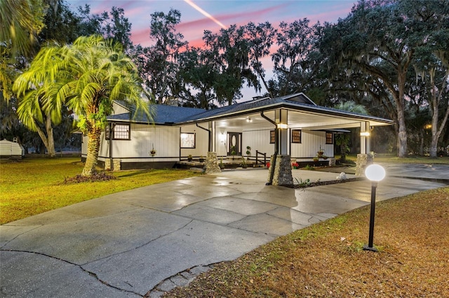 view of front of property with a carport and a yard