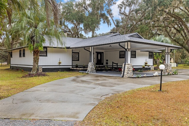 view of front of property with a carport and a front lawn