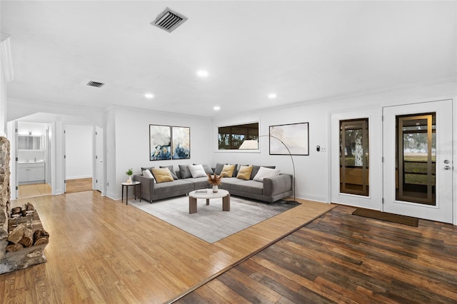 living room with hardwood / wood-style floors, crown molding, and plenty of natural light