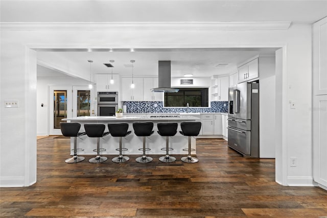 kitchen with pendant lighting, white cabinetry, stainless steel appliances, a center island, and island range hood