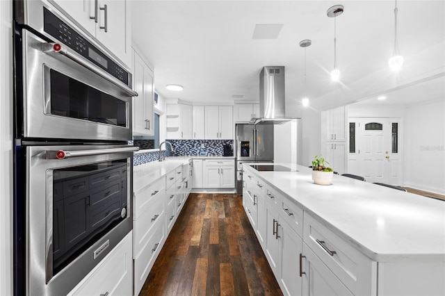 kitchen with a kitchen island, appliances with stainless steel finishes, pendant lighting, island range hood, and white cabinets