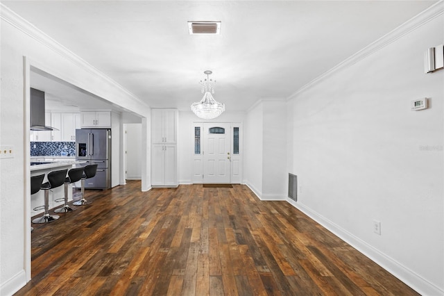 interior space featuring ornamental molding, dark hardwood / wood-style floors, and an inviting chandelier