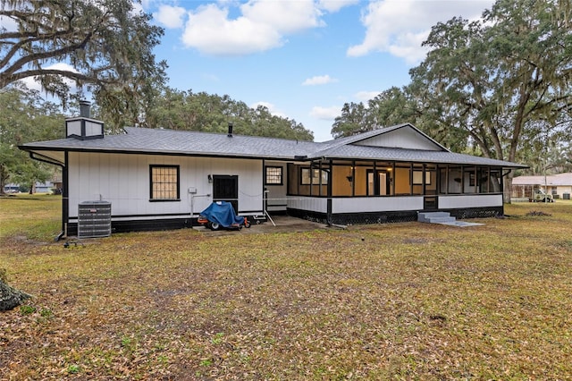 back of property with cooling unit, a lawn, and a sunroom