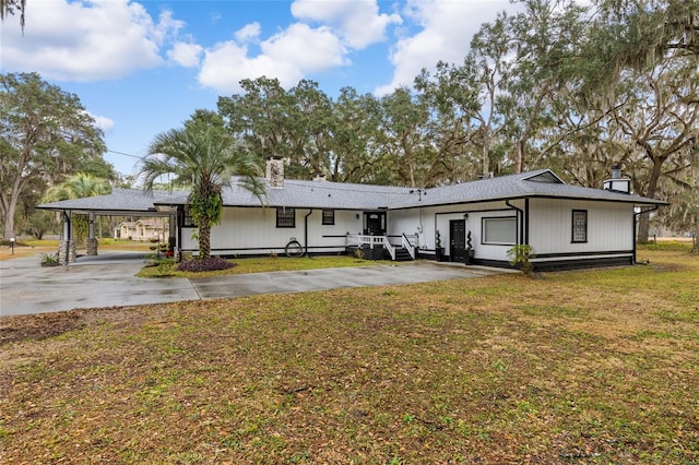 rear view of house with a lawn and a carport