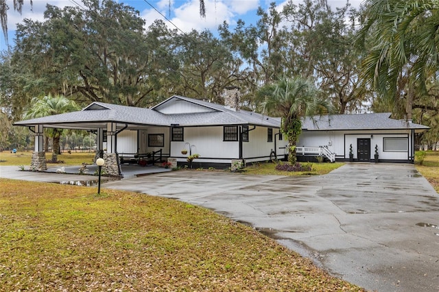 view of front of house featuring a carport and a front yard