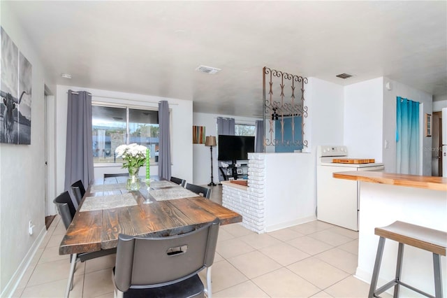 dining room with a fireplace and light tile patterned floors