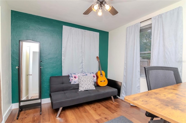 living area with ceiling fan and hardwood / wood-style floors