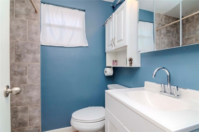 bathroom featuring a shower with shower curtain, vanity, and toilet