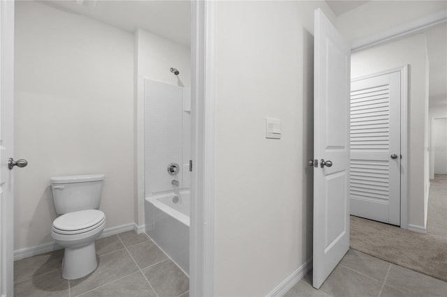 bathroom with toilet, tile patterned flooring, and shower / washtub combination