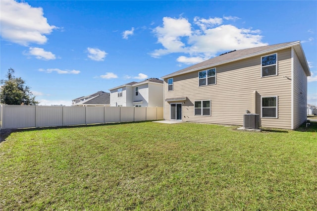 back of property featuring a lawn and central air condition unit