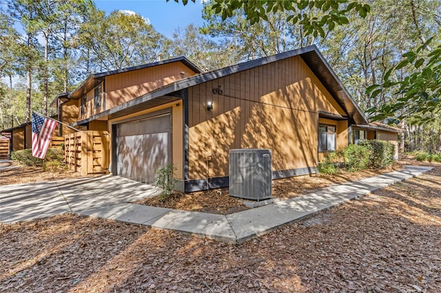 view of side of home with a garage and central AC