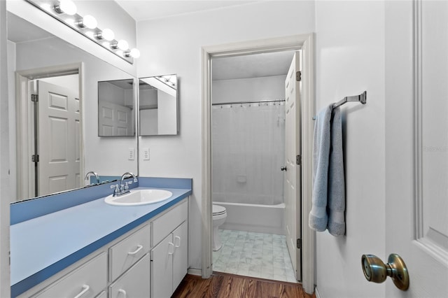 full bathroom with wood-type flooring, shower / bath combination with curtain, vanity, and toilet