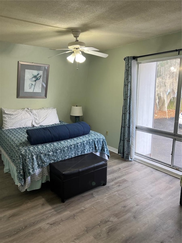 bedroom featuring hardwood / wood-style flooring, ceiling fan, and a textured ceiling