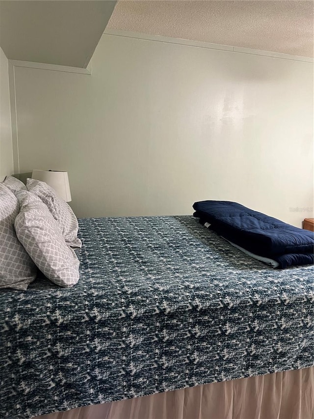 bedroom with hardwood / wood-style floors and a textured ceiling