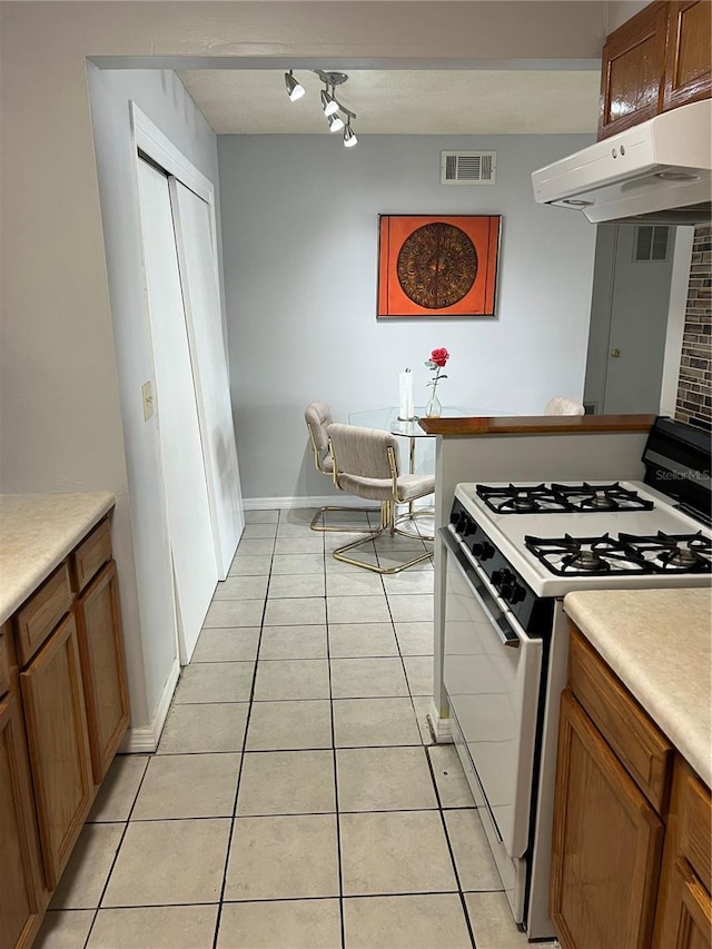 kitchen featuring light tile patterned flooring and white range with gas stovetop