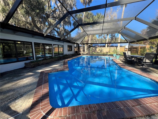 view of pool featuring glass enclosure and a patio