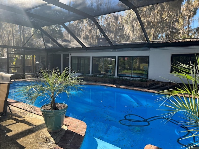 view of swimming pool featuring a lanai