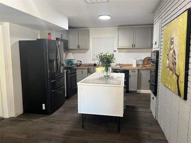 kitchen with black appliances, wood counters, backsplash, dark hardwood / wood-style floors, and gray cabinets