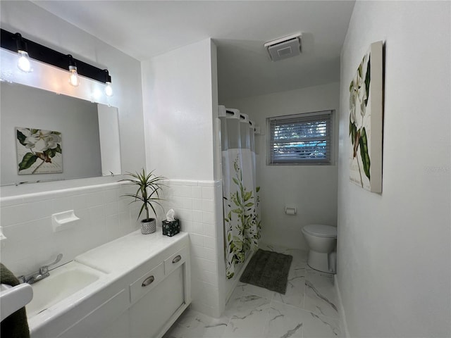 bathroom with toilet, vanity, a shower with curtain, and tile walls