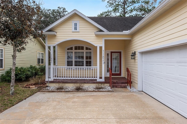 view of exterior entry featuring covered porch and a garage