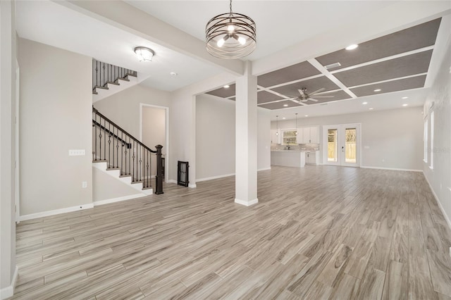 unfurnished living room featuring beamed ceiling, coffered ceiling, ceiling fan, and light hardwood / wood-style flooring