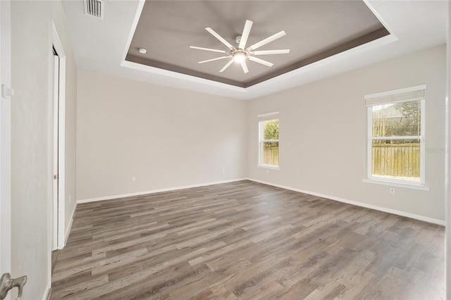 spare room featuring hardwood / wood-style floors, a tray ceiling, and ceiling fan